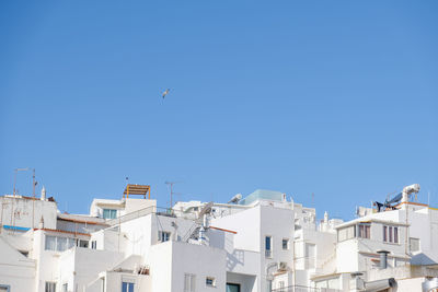 Low angle view of buildings against clear blue sky