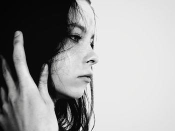 Portrait of young woman looking away against white background