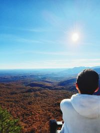 Rear view of man looking at mountain against sky