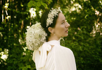 Woman in white blouse with flower bouquet and headband v