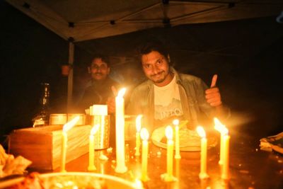 View of a man holding burning candles