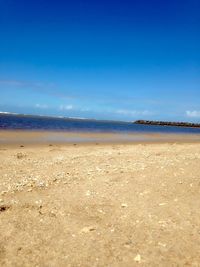 Scenic view of beach against blue sky