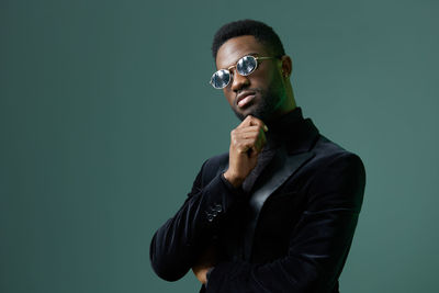 Young man standing against black background