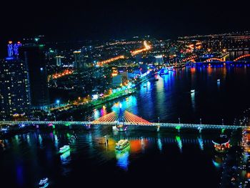 High angle view of illuminated buildings by river at night