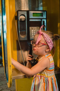 Little girl on the old phone booth