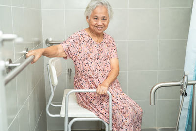 Asian senior woman patient use toilet bathroom handle security concept.