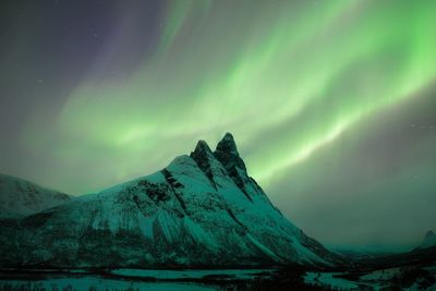 Scenic view of snowcapped mountains against sky at night