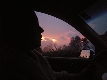 Silhouette woman seen through car windshield
