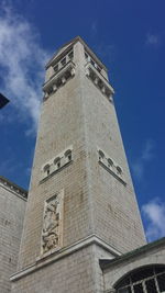 Low angle view of clock tower against cloudy sky