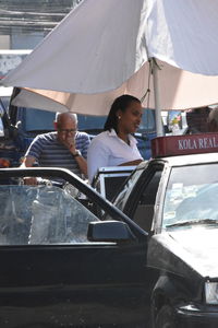 People standing by car on road