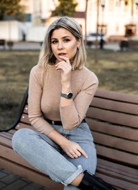 Portrait of young woman sitting on bench