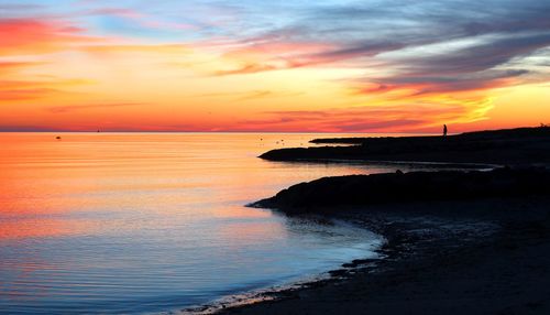 Scenic view of sea against orange sky