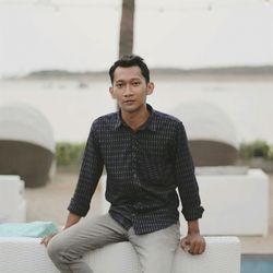 Portrait of young man sitting outdoors