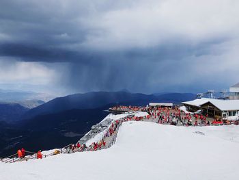 People on snow covered mountain against sky