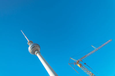 Low angle view of communications tower against blue sky