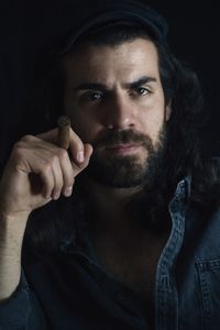 Portrait of mid adult man against black background