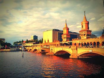 Bridge over river against cloudy sky