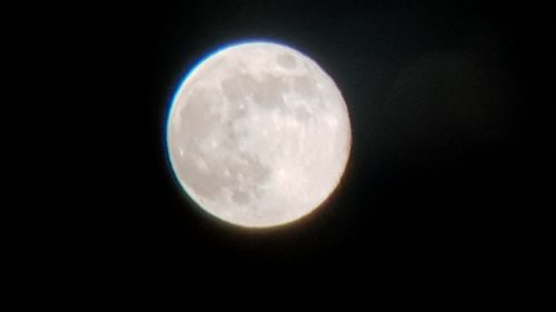 Low angle view of full moon against sky at night