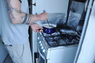 Midsection of man preparing food in kitchen