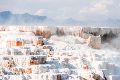 Panoramic view of snow covered land against sky