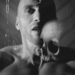 Meditation about death. young man thinking, headshot, looking at camera, mouth open, breathing skull 