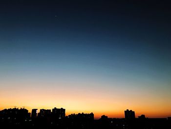 Illuminated cityscape against sky at night