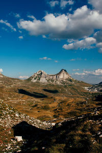 Scenic view of mountains against cloudy sky