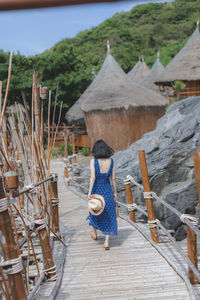 Rear view of woman walking on wood