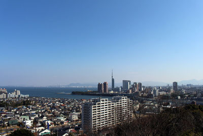 Aerial view of city buildings against blue sky