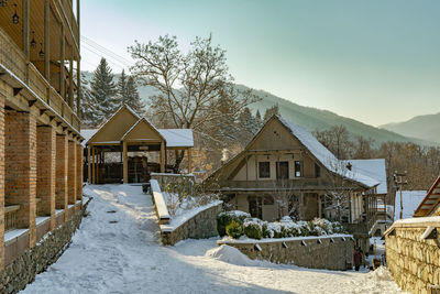 Snow covered houses and buildings against sky