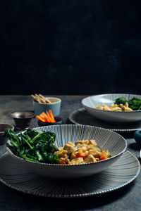 Delicious thai curry coconut chicken, accompanied by tender vegetables and spinach, in a modern blue plate