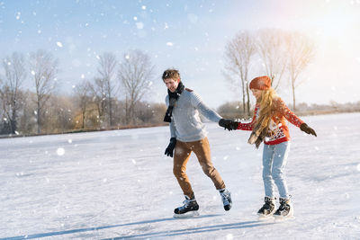 Full length of man and woman walking on snow