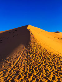 Scenic view of desert against clear blue sky