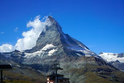 Scenic view of snowcapped mountains against blue sky