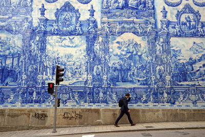 Man walking against graffiti wall