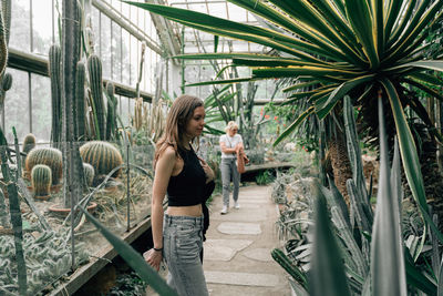 Side view of woman standing against plants