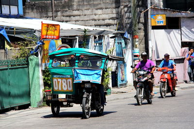 People driving vehicles on city street