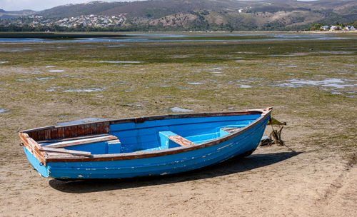 Boat moored on shore by lake