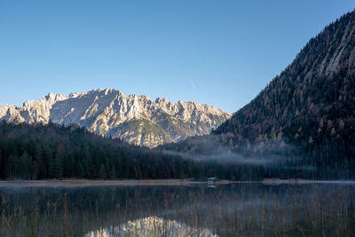 Scenic view of lake and mountains against clear sky