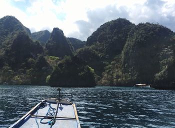 Scenic view of lake by mountains against sky