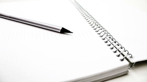 Close-up of pen on table against white background