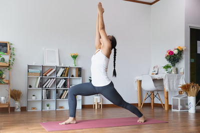 Woman with arms raised at home