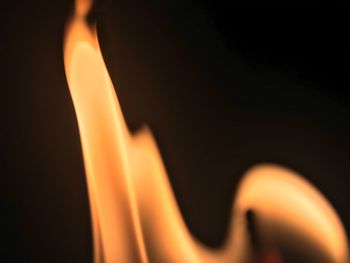 Close-up of illuminated candle against black background