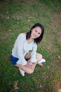 High angle portrait of smiling woman sitting on grass