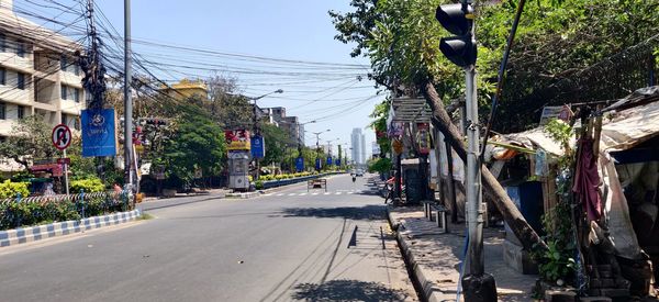 Road by buildings in city against sky