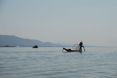 People in sea against sky