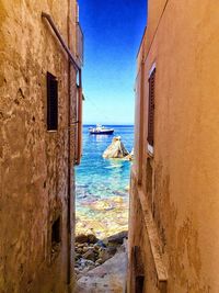 Buildings by sea against sky