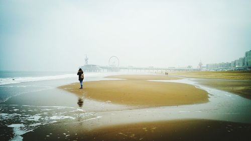 Full length of man on beach against clear sky