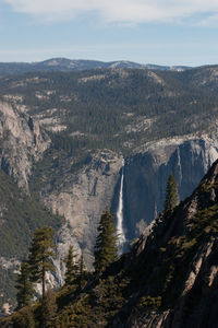 Scenic view of trees and mountains against sky