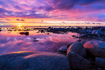 Scenic view of sea against dramatic sky during sunset